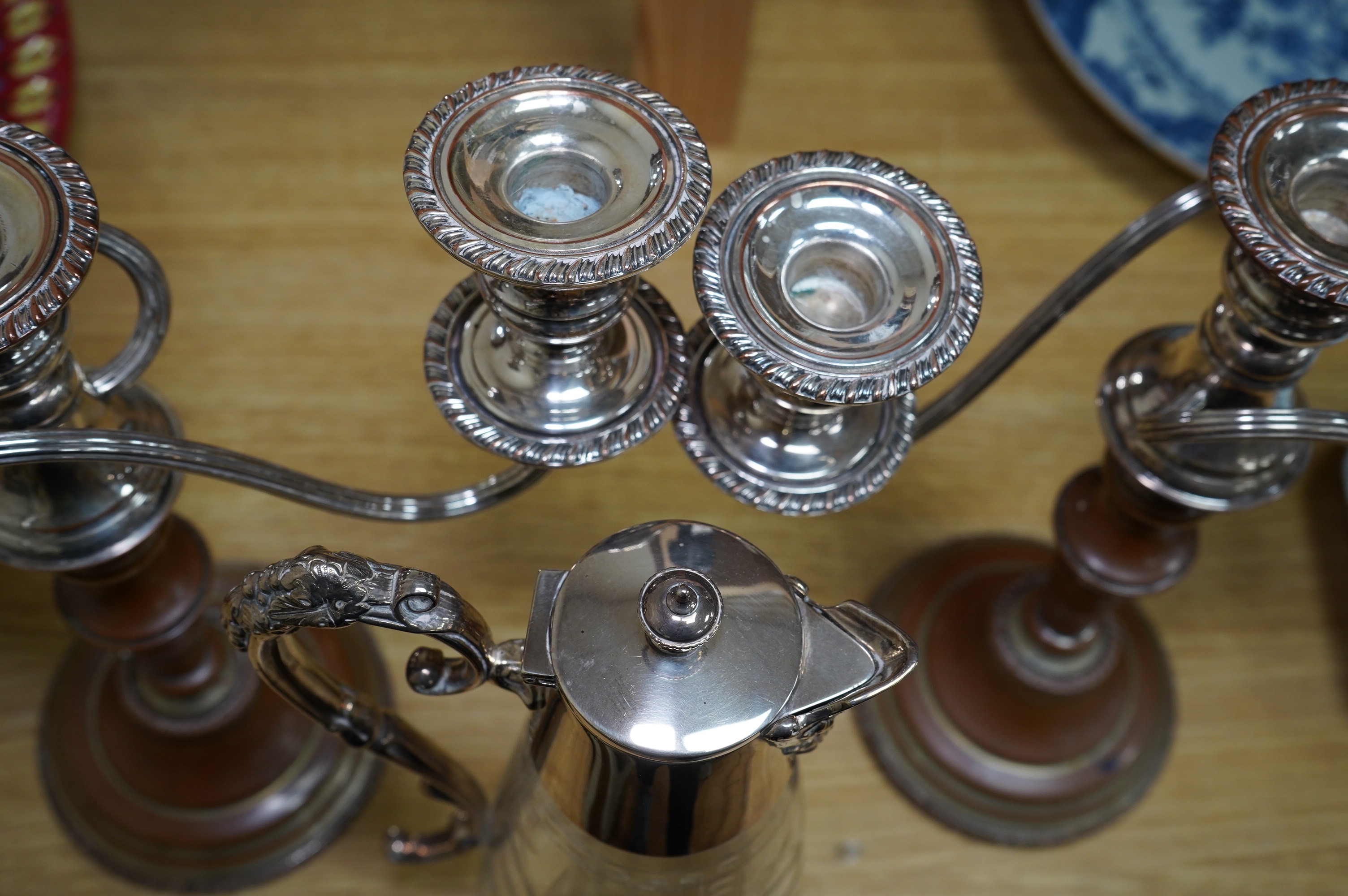 A Victorian silver plated claret jug, together with a pair of candelabra, 30cm. Condition - worn